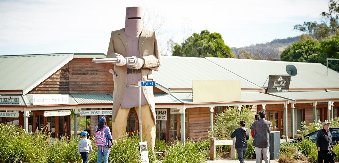 Tourists posing by Big Ned Kelly statue in Glenrowan